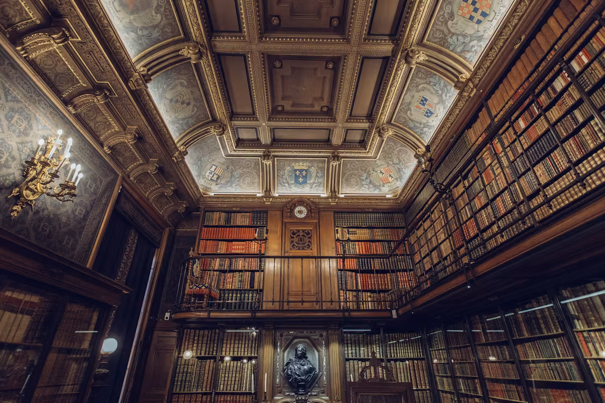 Bibliothek mit Holzregalen über zwei Geschosse und Kassettendecke